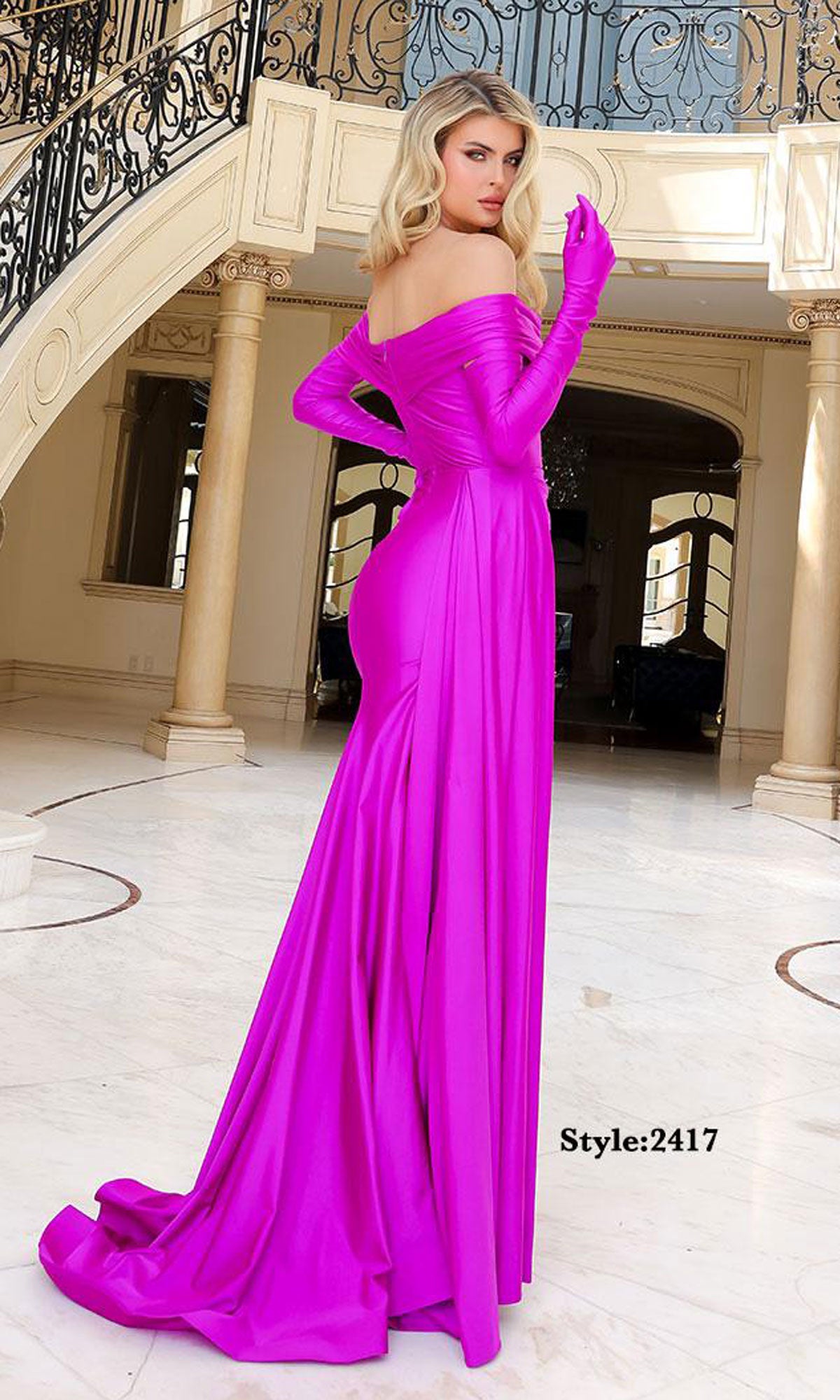 A woman in a bright fuchsia Jessica Angel 2417 long prom dress with matching gloves stands on a marble floor in a grand interior. Text reads: